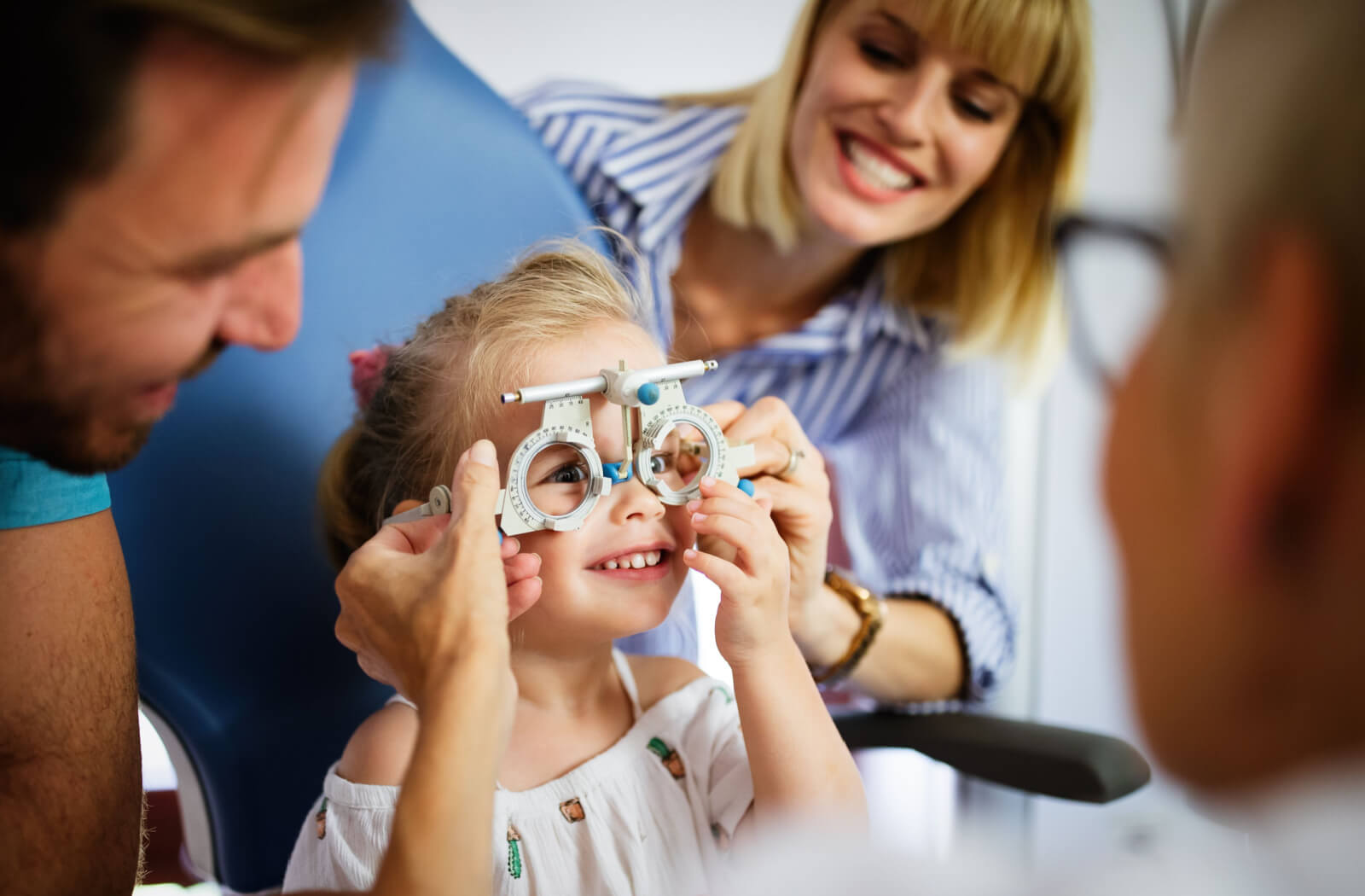 Parents on family eye exam with their daughter