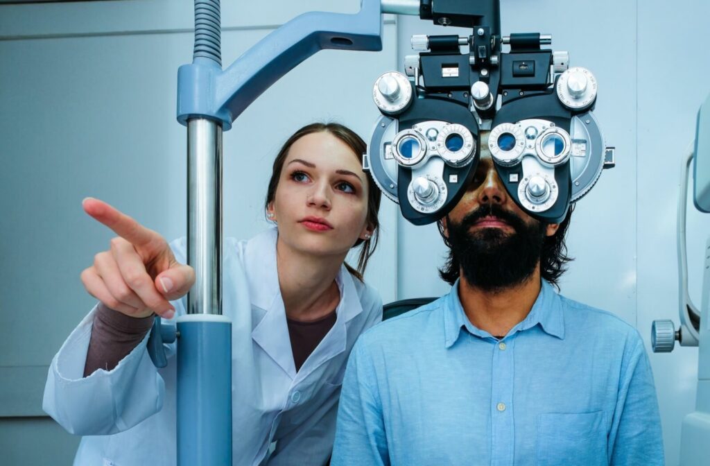 Optometrist conducting an eye exam with a patient using a phoropter.